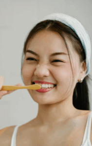Asian female brushing teeth