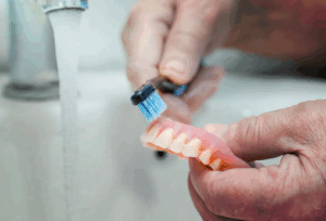 Man brushing his dentures