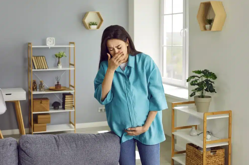 Pregnant woman feeling unwell, highlighting discomfort from gingivitis during pregnancy.