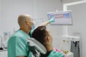 Dentist explaining dental scan during an oral cancer screening in Singapore.