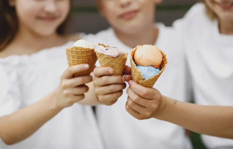 Children holding ice cream cones, representing soft and cold foods when deciding what to eat after tooth extraction.