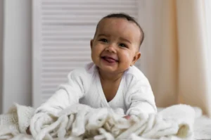Smiling infant sticking out their tongue.