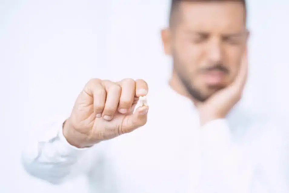 Man holding extracted tooth after procedure